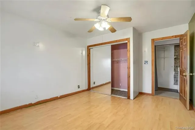an empty room with closet and a ceiling fan