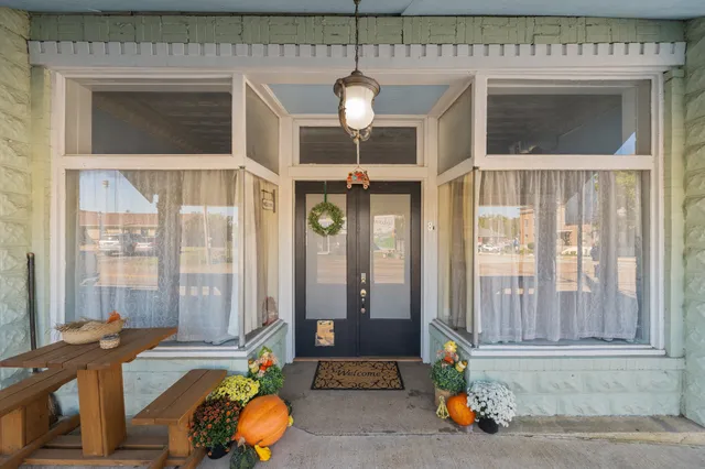 a room with chandelier fan and a large window