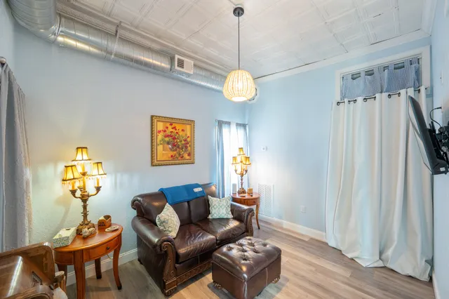 a bedroom with a bed a flat tv screen and a ceiling fan