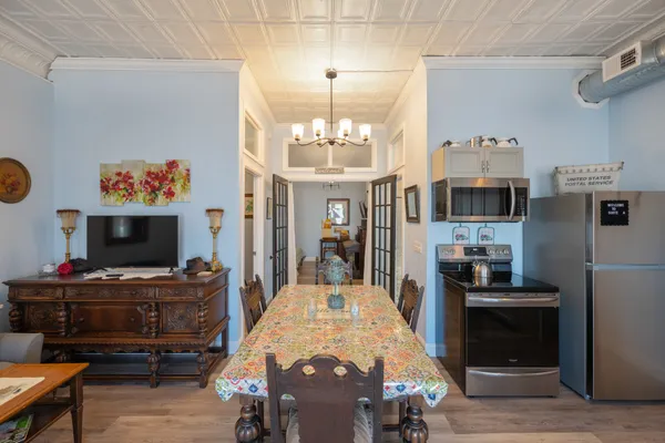 a living room with stainless steel appliances furniture a fireplace and a flat screen tv