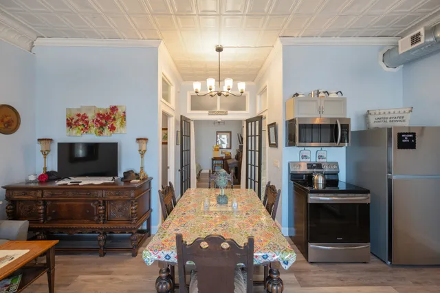 a living room with stainless steel appliances furniture a fireplace and a flat screen tv