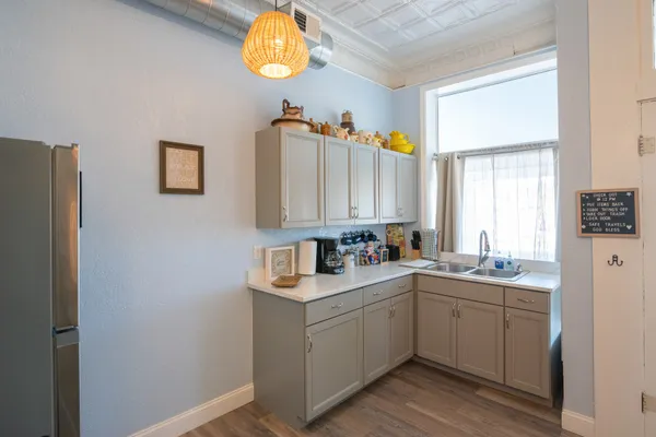 a kitchen with a sink cabinets and wooden floor