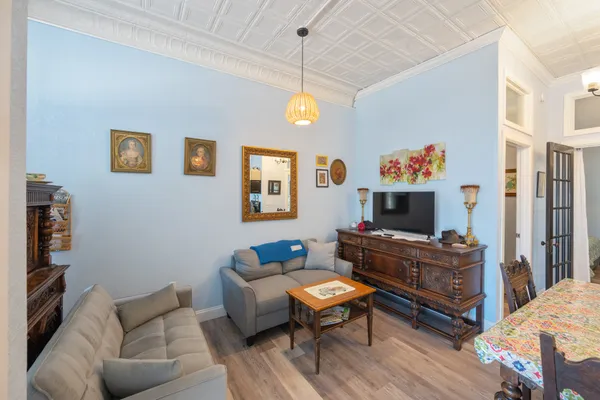 a living room with furniture a flat screen tv and a dining table