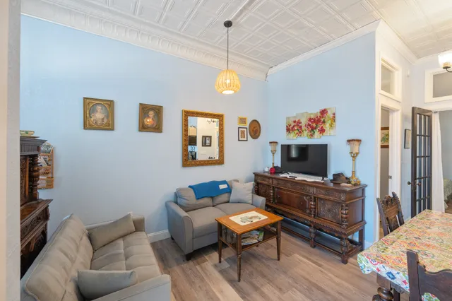 a living room with furniture a flat screen tv and a dining table