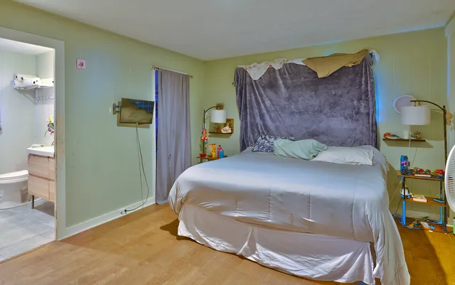 a bedroom with a bed and a painting on the wall
