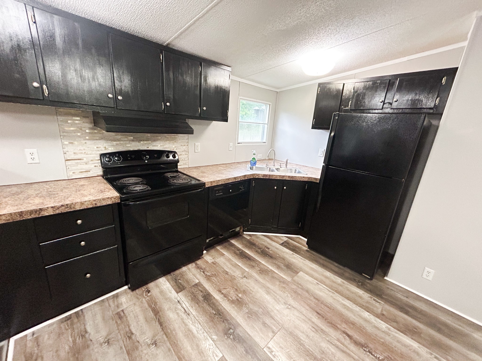 398 2nd Street Big Sandy, TN 38221 - Photo 11 of 26 a kitchen with a sink and wooden cabinets