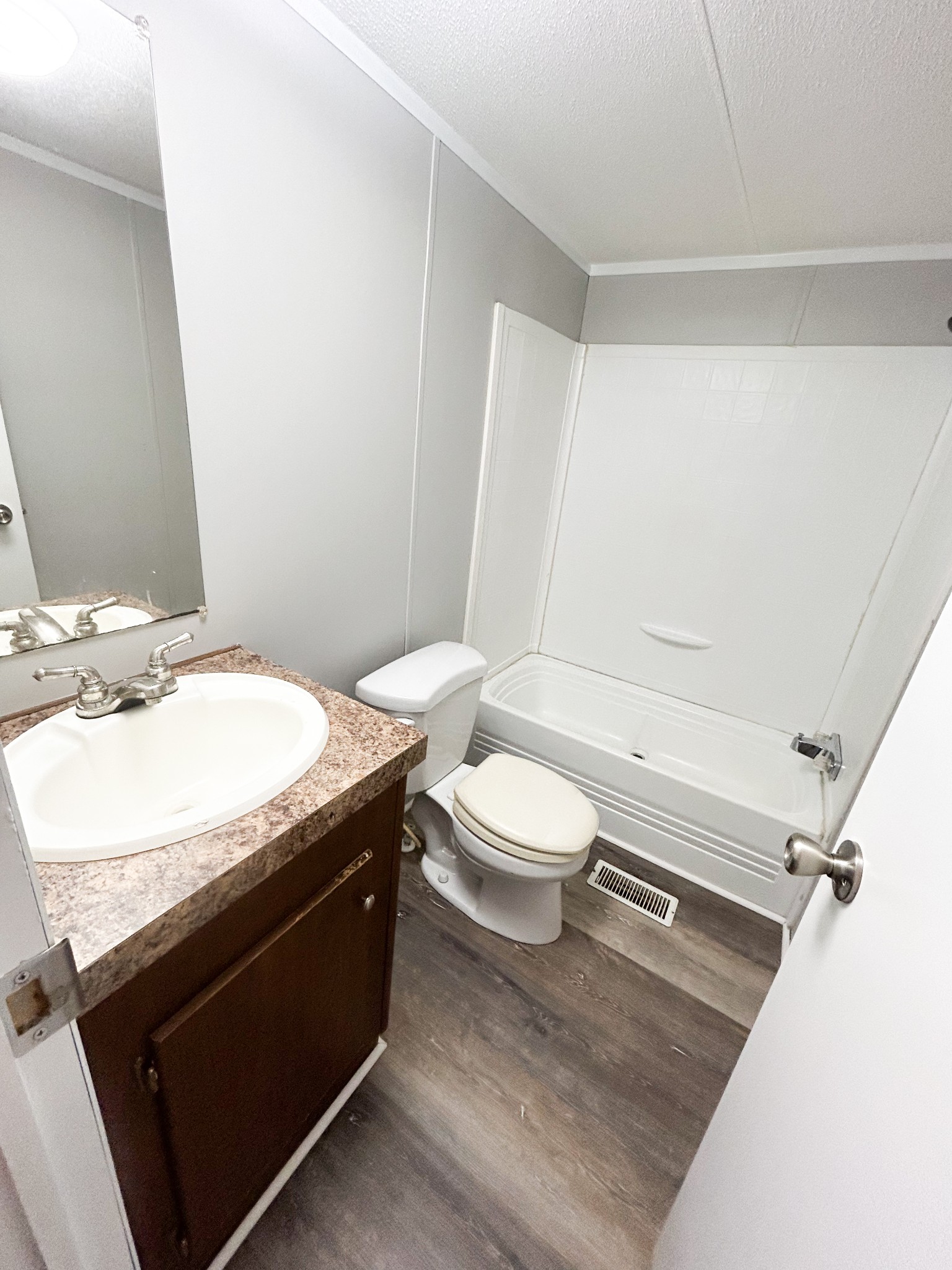 398 2nd Street Big Sandy, TN 38221 - Photo 19 of 26 a bathroom with a granite countertop sink a toilet a mirror and vanity