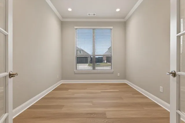 a view of empty room with wooden floor and fan