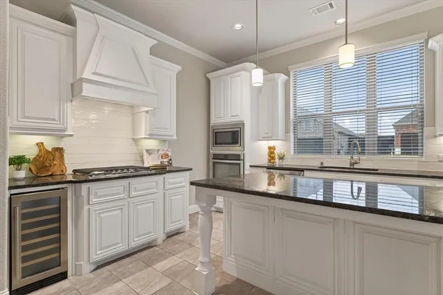a kitchen with stainless steel appliances granite countertop a sink and a stove