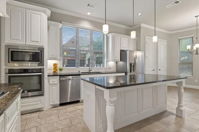 a kitchen with stainless steel appliances granite countertop a sink and a microwave