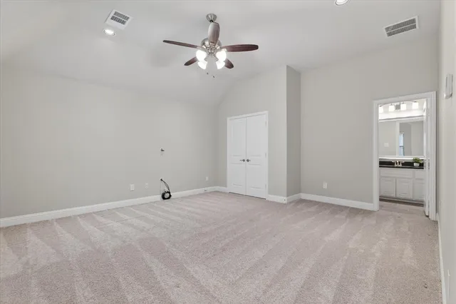 a view of an empty room with a chandelier fan