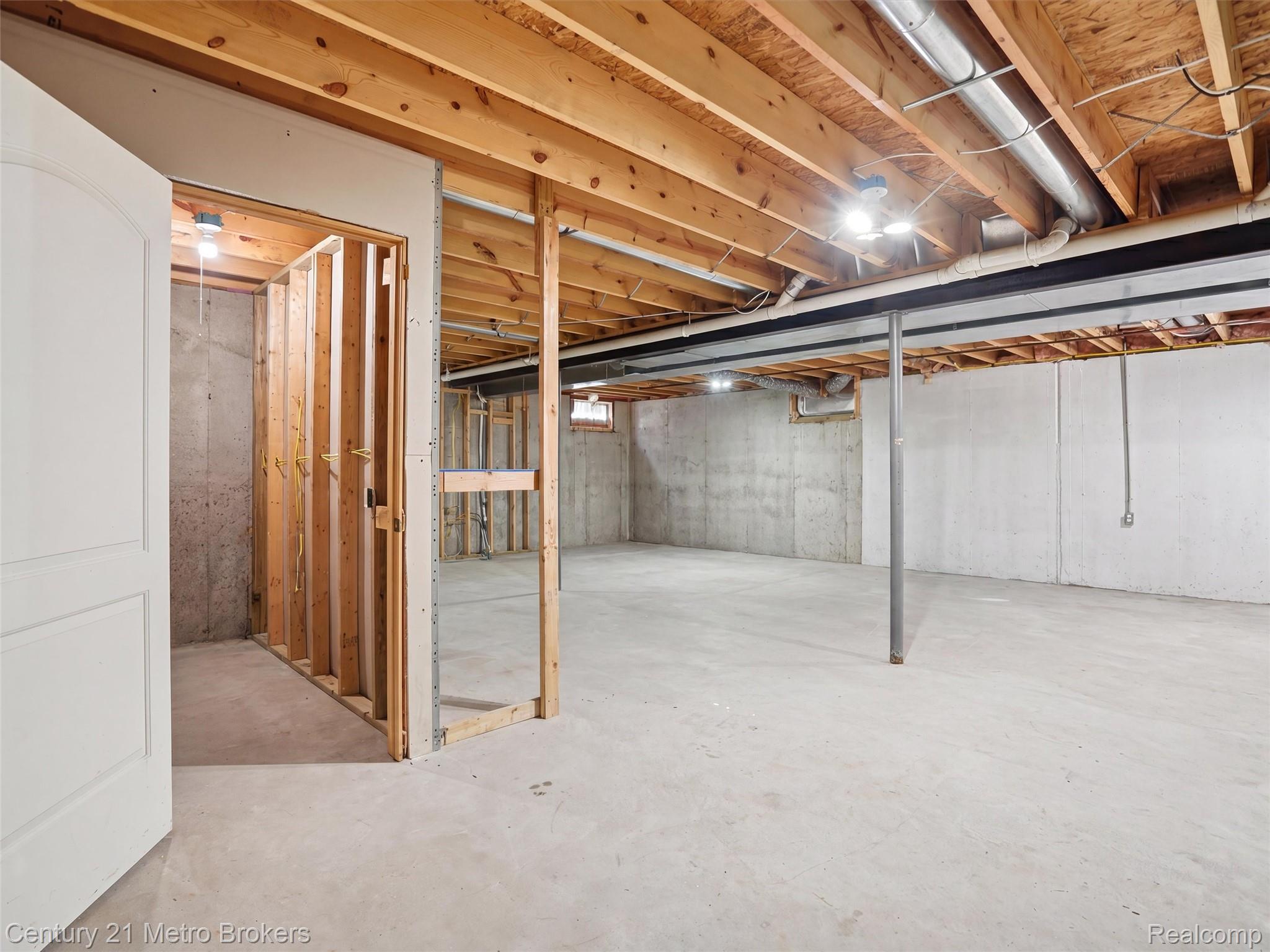 11447 North Latson Road Linden, MI 48451 - Photo 27 of 52 Unfinished basement featuring concrete flooring, exposed wooden ceiling joists, and concrete walls