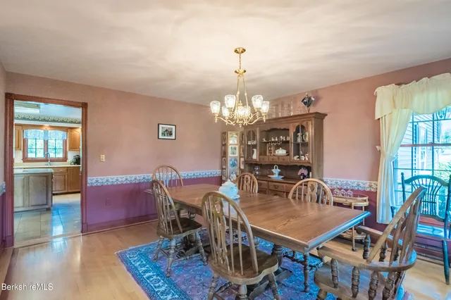 a kitchen with stainless steel appliances granite countertop a stove top oven a refrigerator and a dining table with a large window