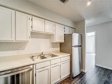 a kitchen with appliances a sink and cabinets
