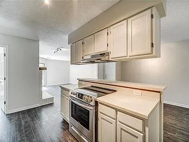 a kitchen with cabinets and wooden floor