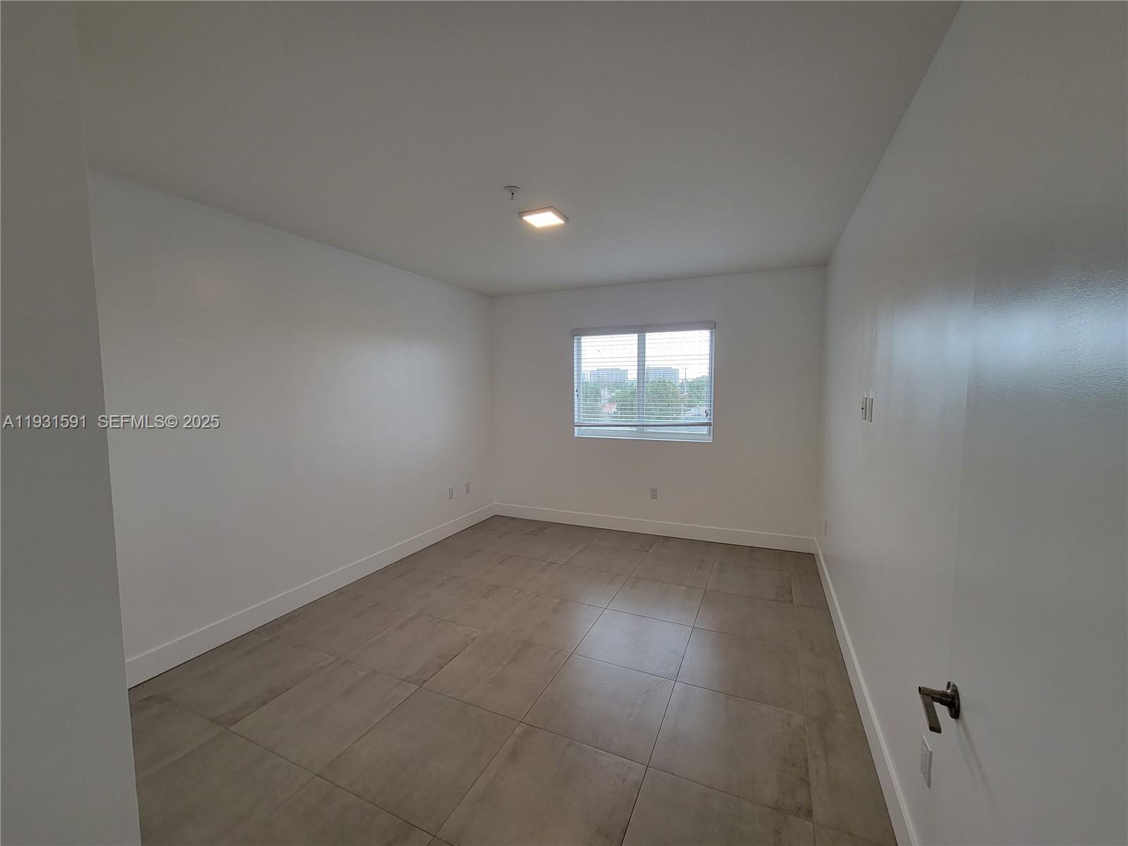 6001 West Flagler Street, Unit 302 Miami, FL 33144 - Photo 5 of 12 an empty room with a empty space and windows