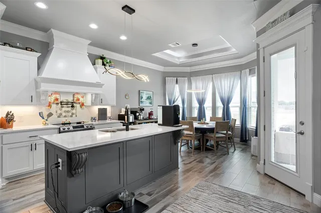 a kitchen that has a lot of cabinets in it and wooden floors