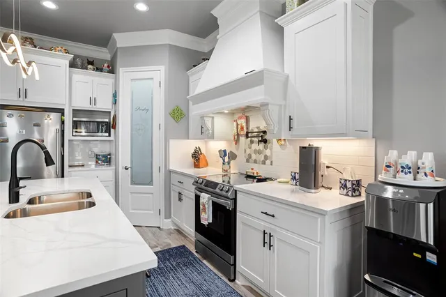 a kitchen with a sink appliances and cabinets