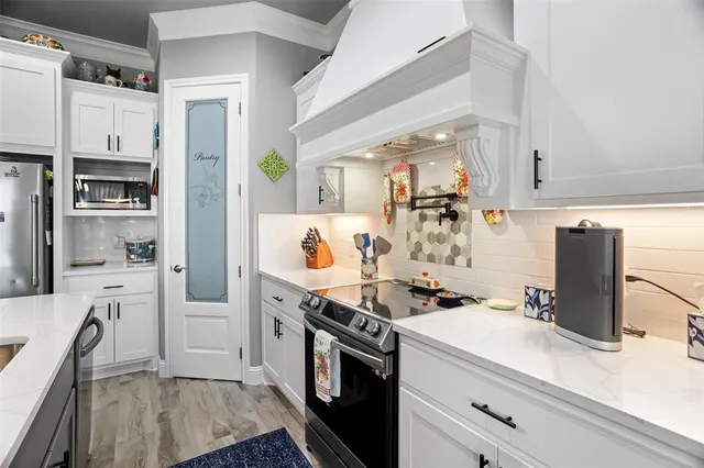 a kitchen with stainless steel appliances a sink a microwave a refrigerator and cabinets