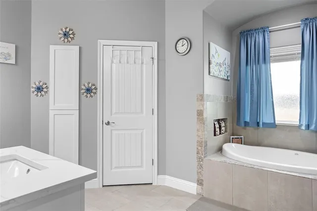 a white bath tub sitting in a bathroom next to a window