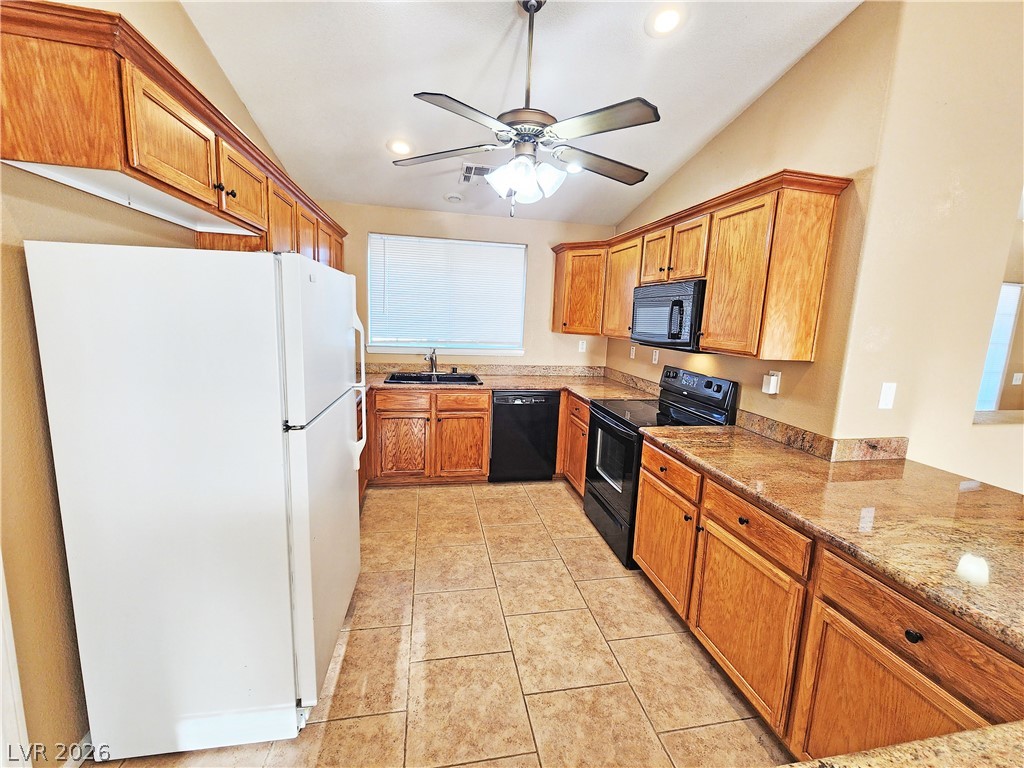 3680 Ravine Avenue Pahrump, NV 89048 - Photo 8 of 28 Kitchen with a sink, vaulted ceiling, brown cabinets, ceiling fan, and black appliances