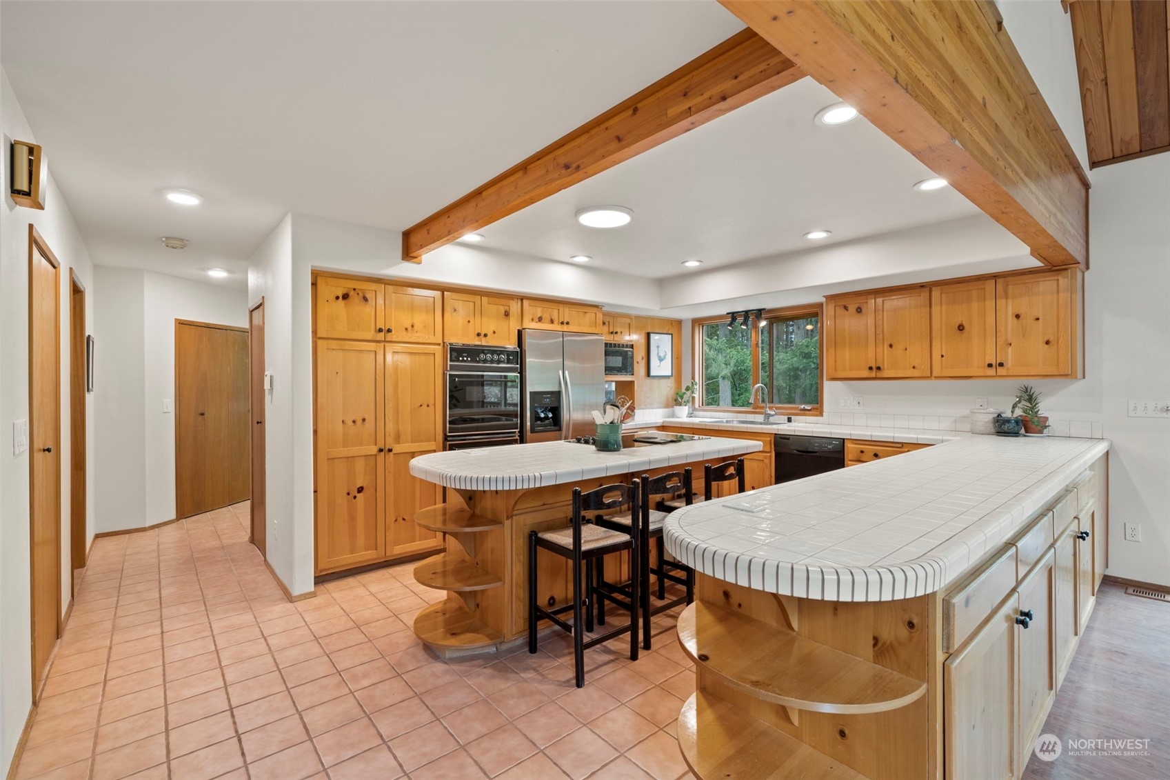 835 Hyak Way Fox Island, WA 98333 - Photo 5 of 38 a kitchen with stainless steel appliances kitchen island granite countertop a table chairs sink and cabinets