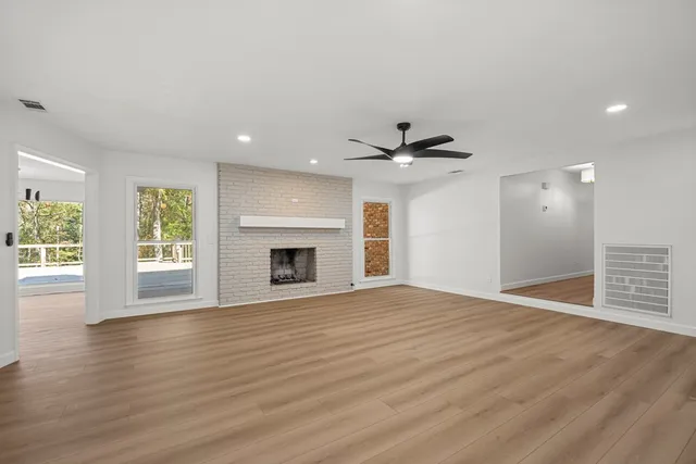 a view of an empty room with a window and fireplace