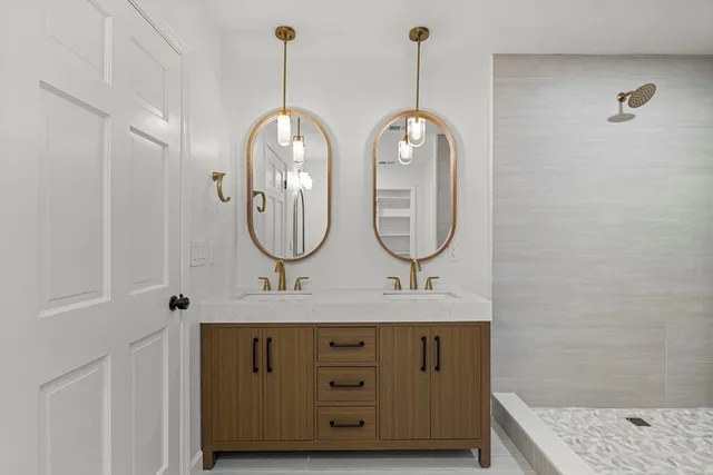 a bathroom with a granite countertop sink a mirror and a shower