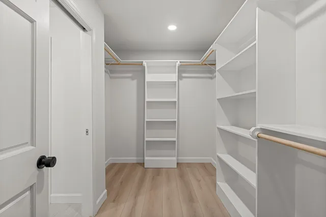 a view of walk in closet with empty racks