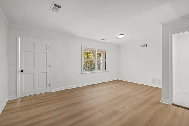 a view of an empty room with wooden floor