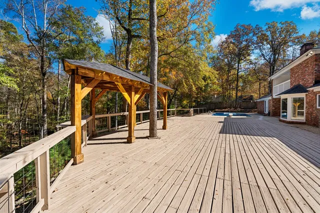 a view of a balcony with wooden floor and trees
