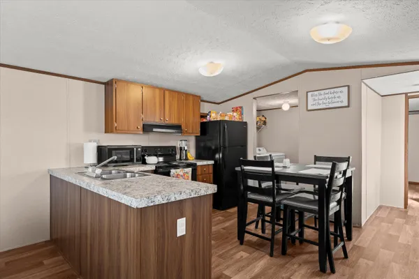 a kitchen with a stove a refrigerator and a dining table