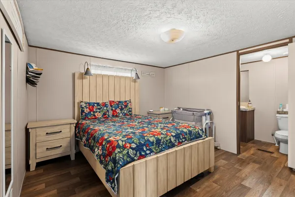 a bedroom with bed and wooden floor