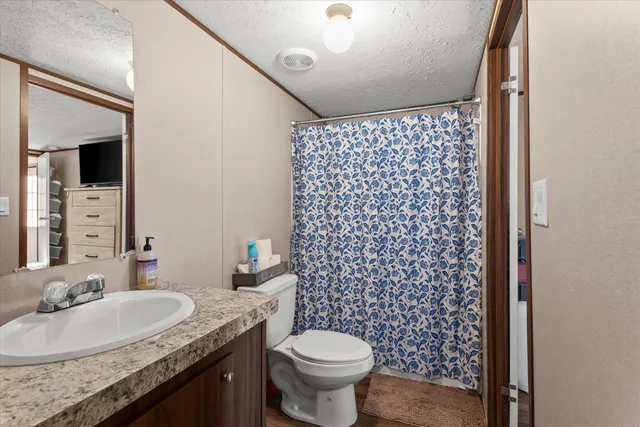a bathroom with a granite countertop toilet sink and mirror