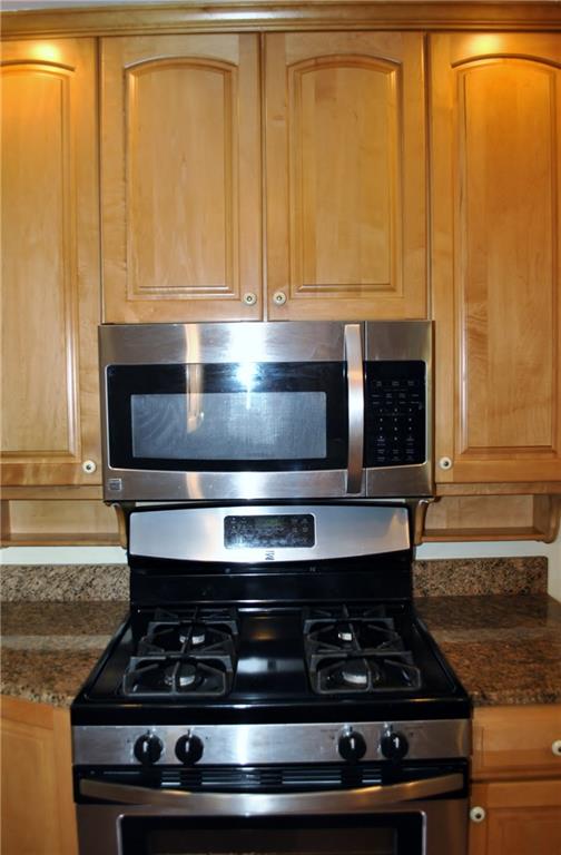228 Bascom Avenue Pittsburgh, PA 15214 - Photo 17 of 24 Stainless gas stove and microwave with loads of cabinets and granite countertops.
