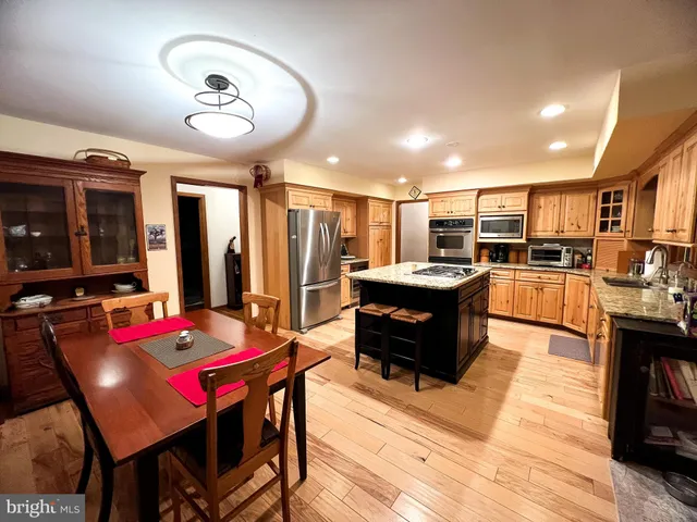 a living room with stainless steel appliances kitchen island granite countertop furniture and rug