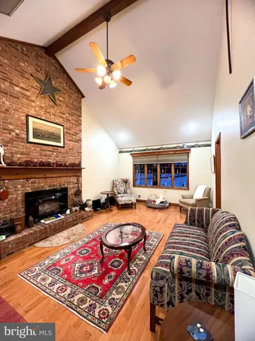 a living room with furniture a fireplace and chandelier