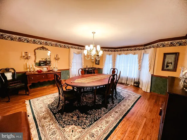 a dining room with furniture a rug and wooden floor