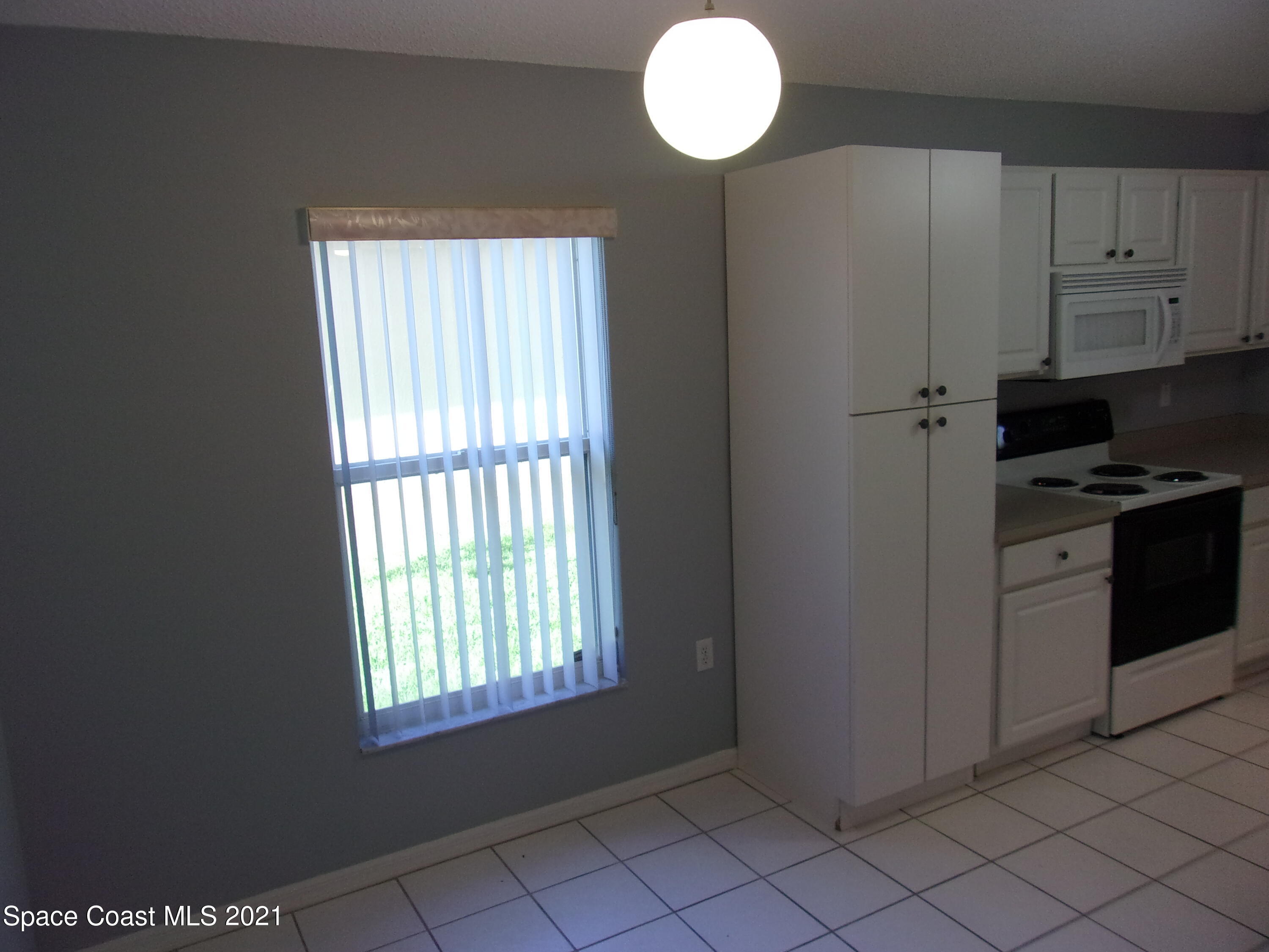 3908 Upmann Drive Rockledge, FL 32955 - Photo 11 of 35 a kitchen with cabinets appliances and a window