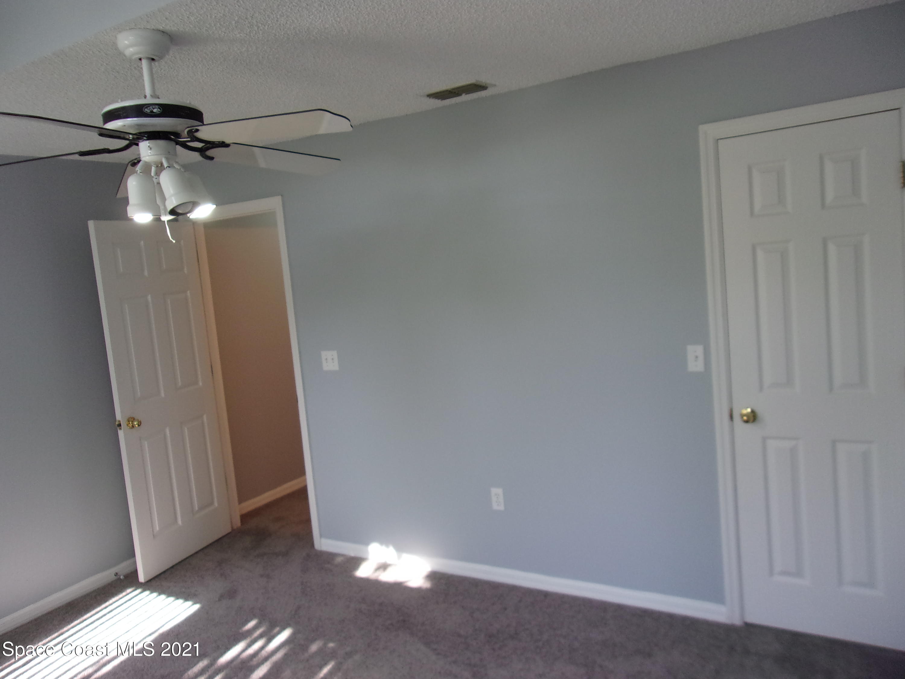 3908 Upmann Drive Rockledge, FL 32955 - Photo 20 of 35 a view of a room with a mirror and a ceiling fan