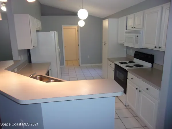 a kitchen with cabinets appliances and a window