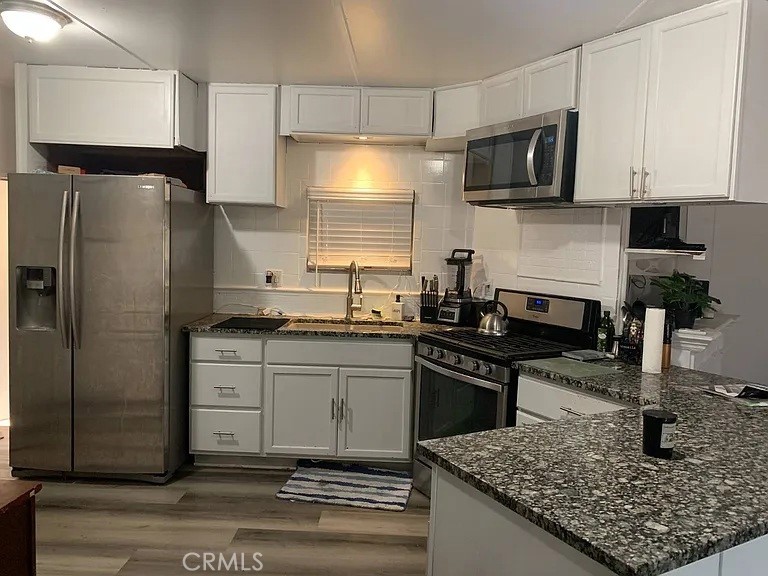 5700 Carbon Canyon Road, Unit 62 Brea, CA 92823 - Photo 3 of 4 a kitchen with stainless steel appliances granite countertop a sink stove microwave and refrigerator
