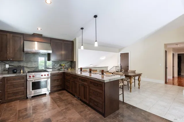 a kitchen with stainless steel appliances granite countertop a sink a stove and a refrigerator