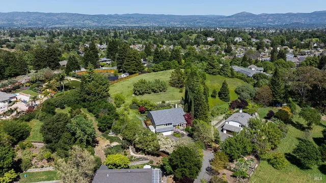 an aerial view of a city with lots of residential buildings and mountain view in back
