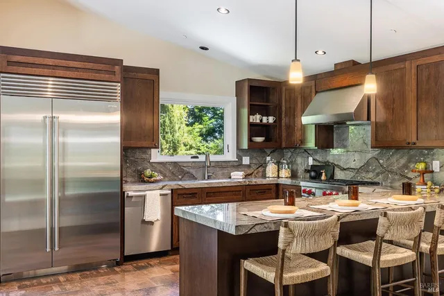 a kitchen with a sink a counter and chairs