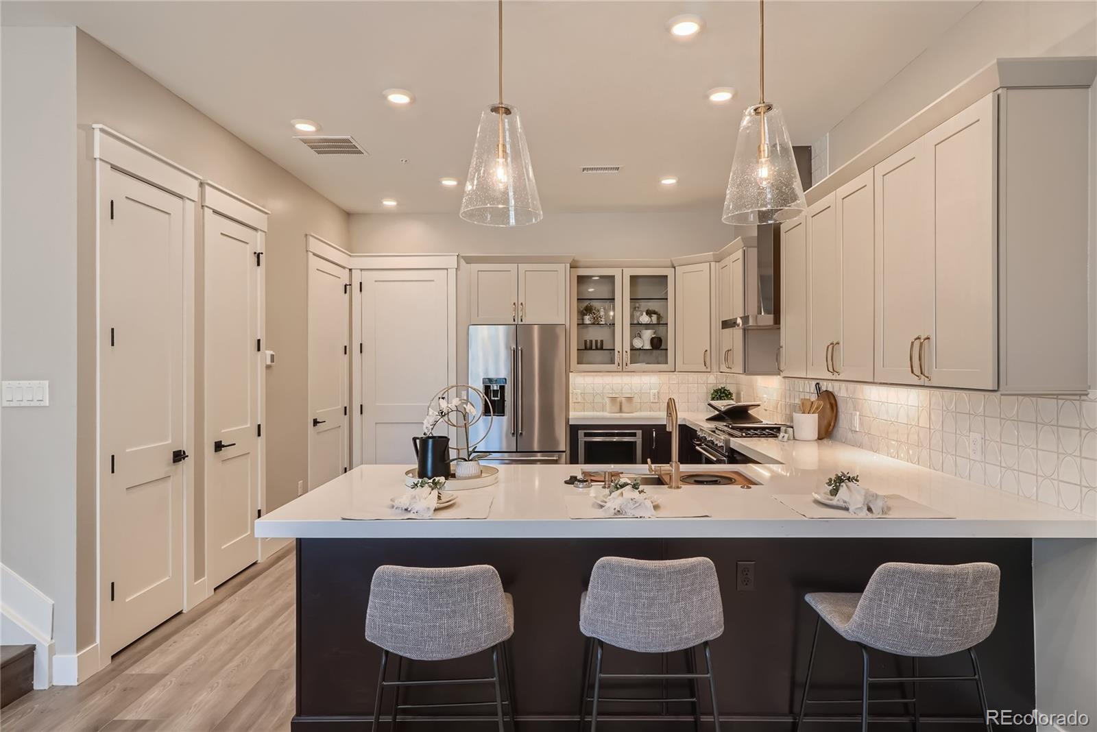 308 East Orchard Road Centennial, CO 80121 - Photo 11 of 26 a kitchen with kitchen island granite countertop a sink and a refrigerator