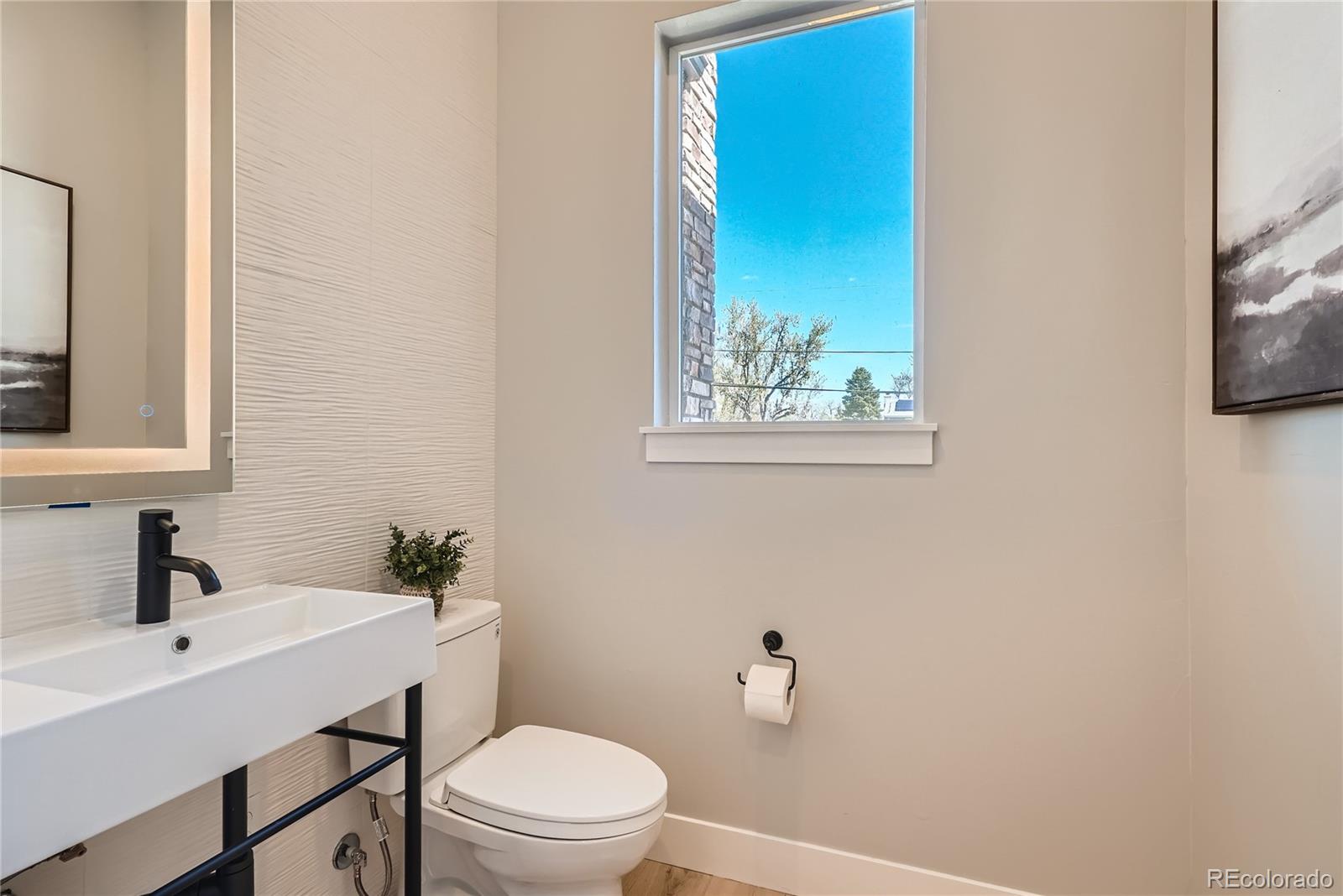 308 East Orchard Road Centennial, CO 80121 - Photo 12 of 26 a bathroom with a toilet a sink and mirror
