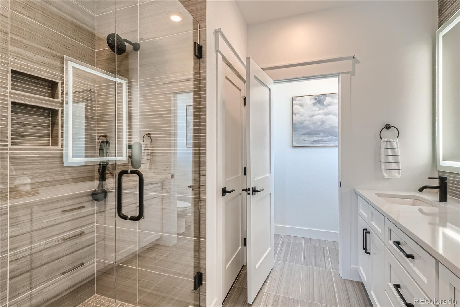 308 East Orchard Road Centennial, CO 80121 - Photo 16 of 26 a bathroom with a shower sink and mirror