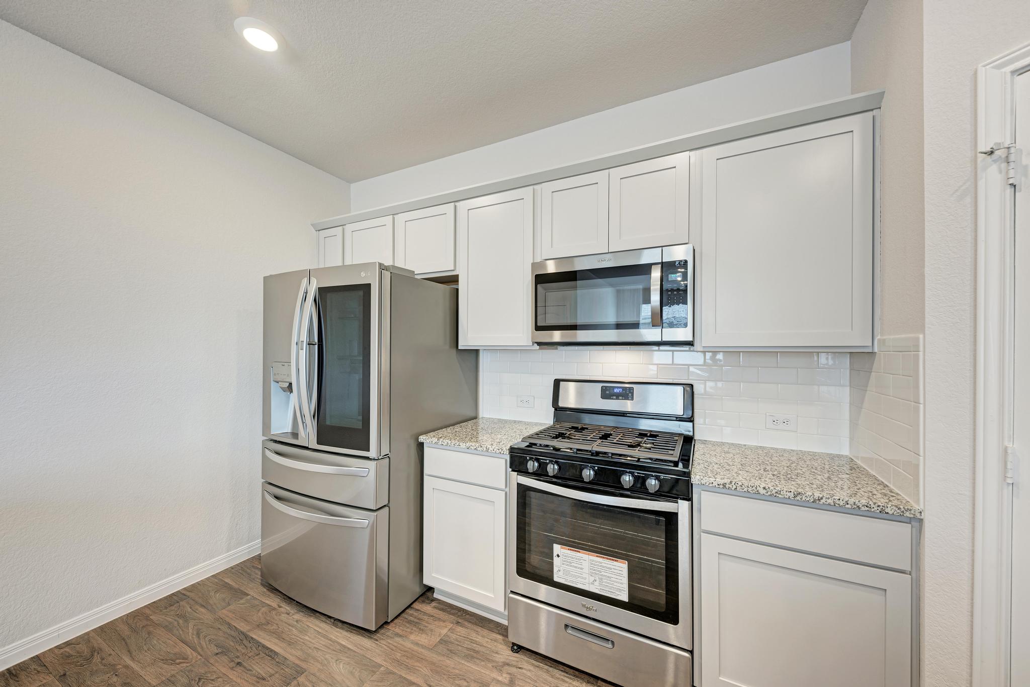 208 Abby Road Georgetown, TX 78626 - Photo 17 of 40 a kitchen with white cabinets and stainless steel appliances