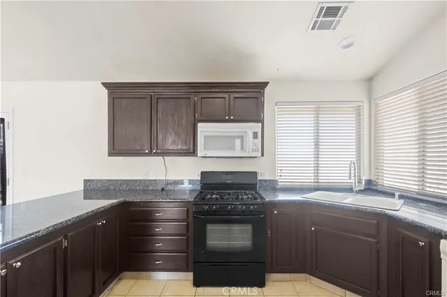 a kitchen with sink a stove and cabinets